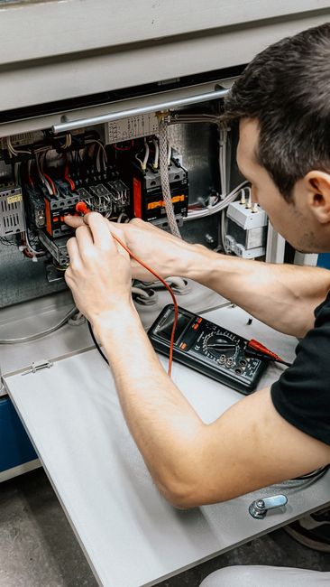 How to Fix LiftMaster Error Code 1-5 (Step by Step) 4 Electrician testing electrical connections with multimeter