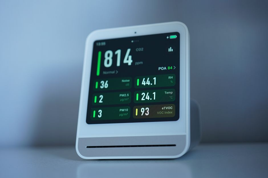 Smart home monitor device on desk showing sensor status display