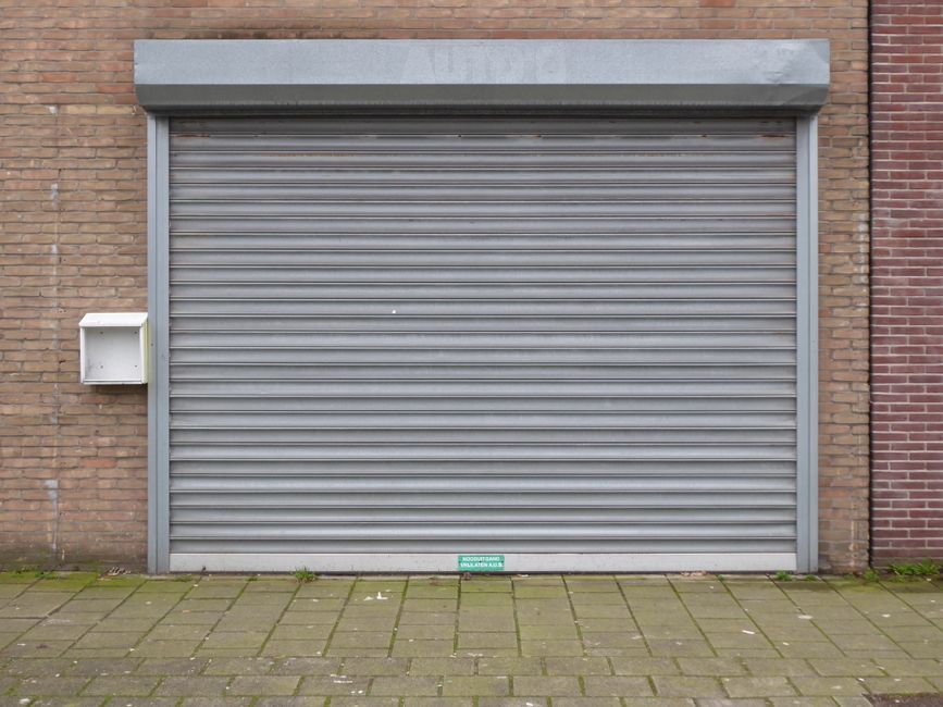How to Fix LiftMaster Error Code 1-5 (Step by Step) 2 Closed metal roller garage door showing track and mechanism