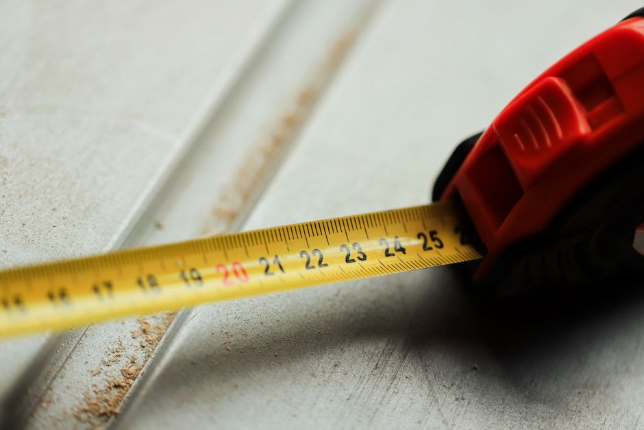 How Much Does a 16x7 Garage Door Weigh? (By Material) 3 Tape measure on construction surface showing measurement accuracy for garage door sizing