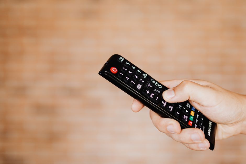 Hand holding a remote control for smart garage door opener