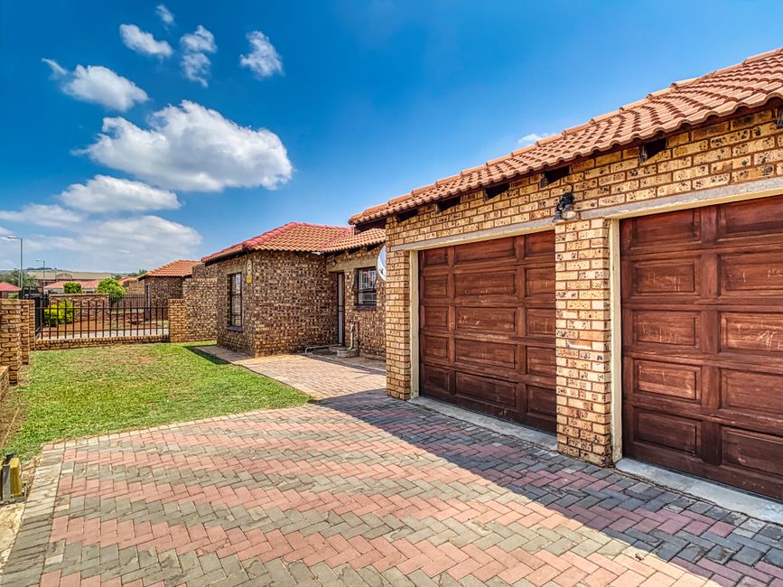 Best Garage Door Opener for Heavy Doors (2026 Picks) 5 Suburban home with heavy double garage door and driveway
