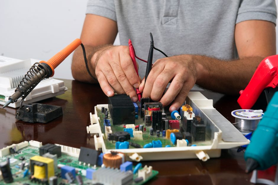 LiftMaster 1/3 HP Troubleshooting: Fix Every Problem Fast 3 Technician working on electronic circuit board for LiftMaster troubleshooting