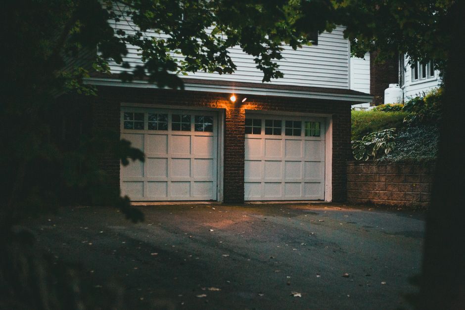 Suburban home garage in evening with smart garage door opener installed
