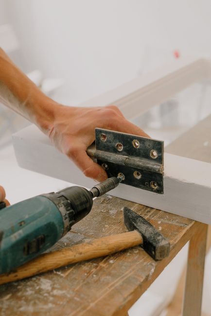 Carpenters Blocks Garage Door: How to Shim a Frame Right 2 Craftsman installing hardware on a wooden door frame during renovation