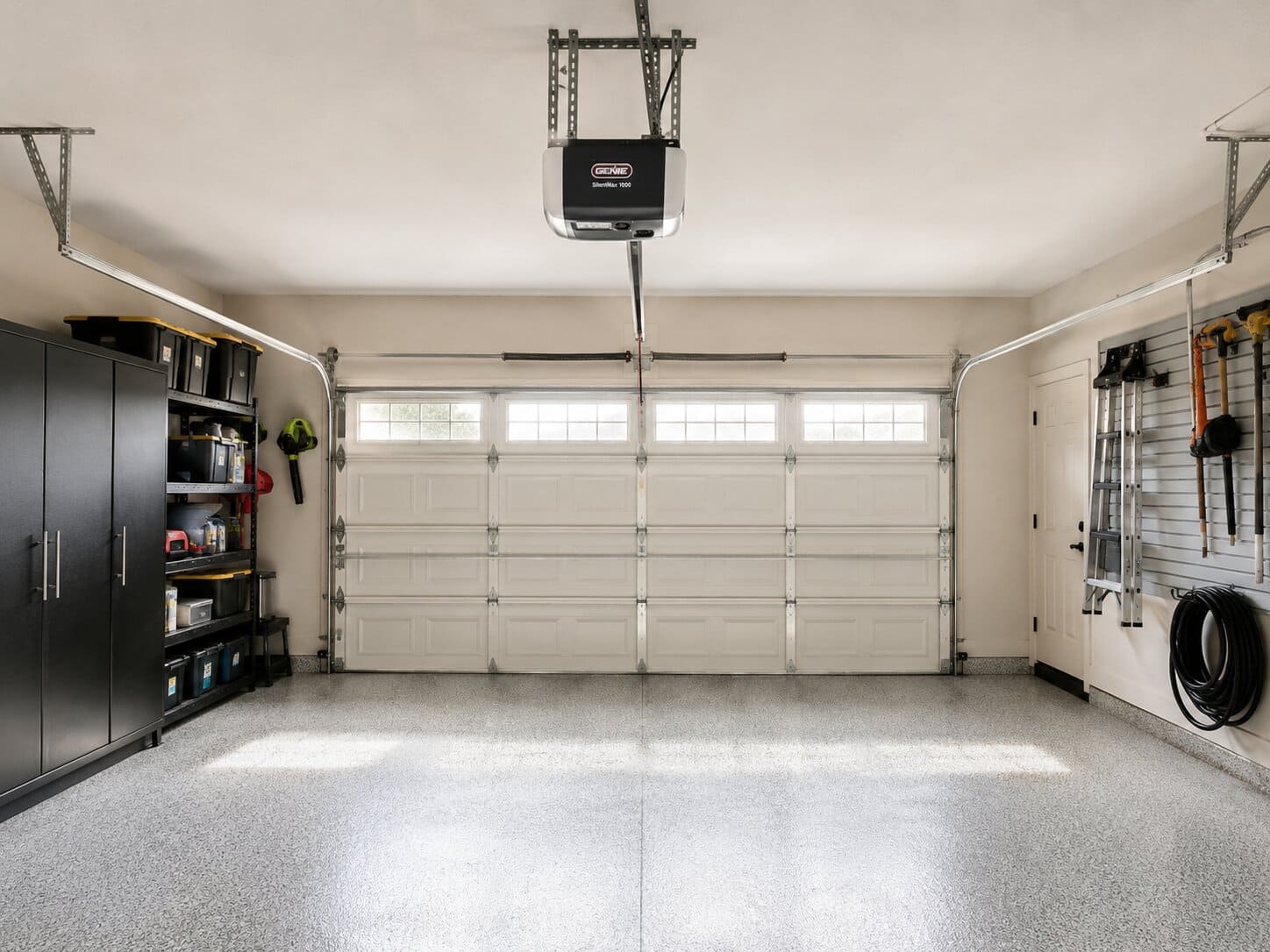 Well-organized garage interior with a double car door and ceiling-mounted screw drive opener