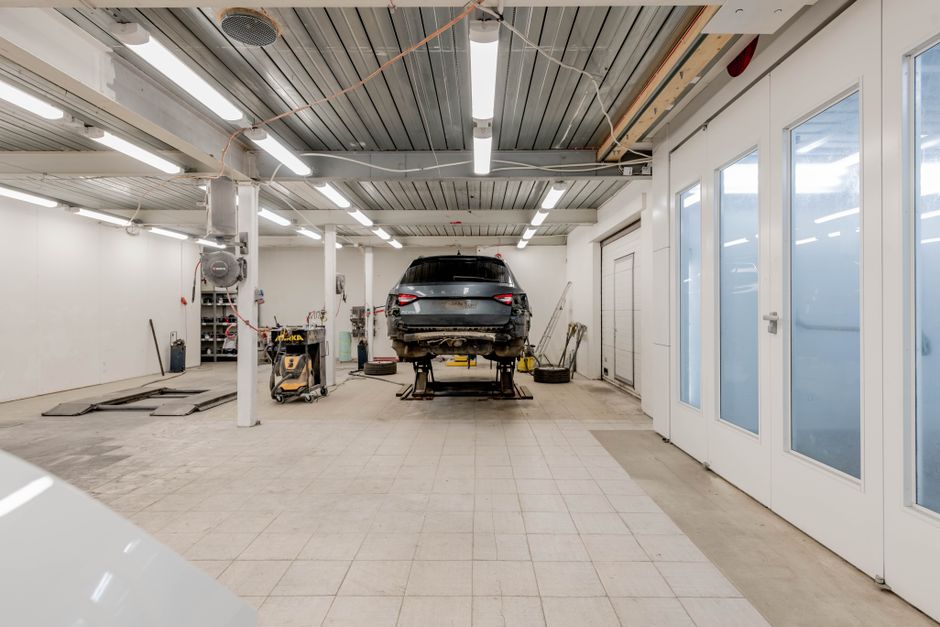 Extra Lights Controlled by the Garage Door Opener: 3 Ways That Work 3 Well-lit garage workshop with extra lighting for a car on a lift