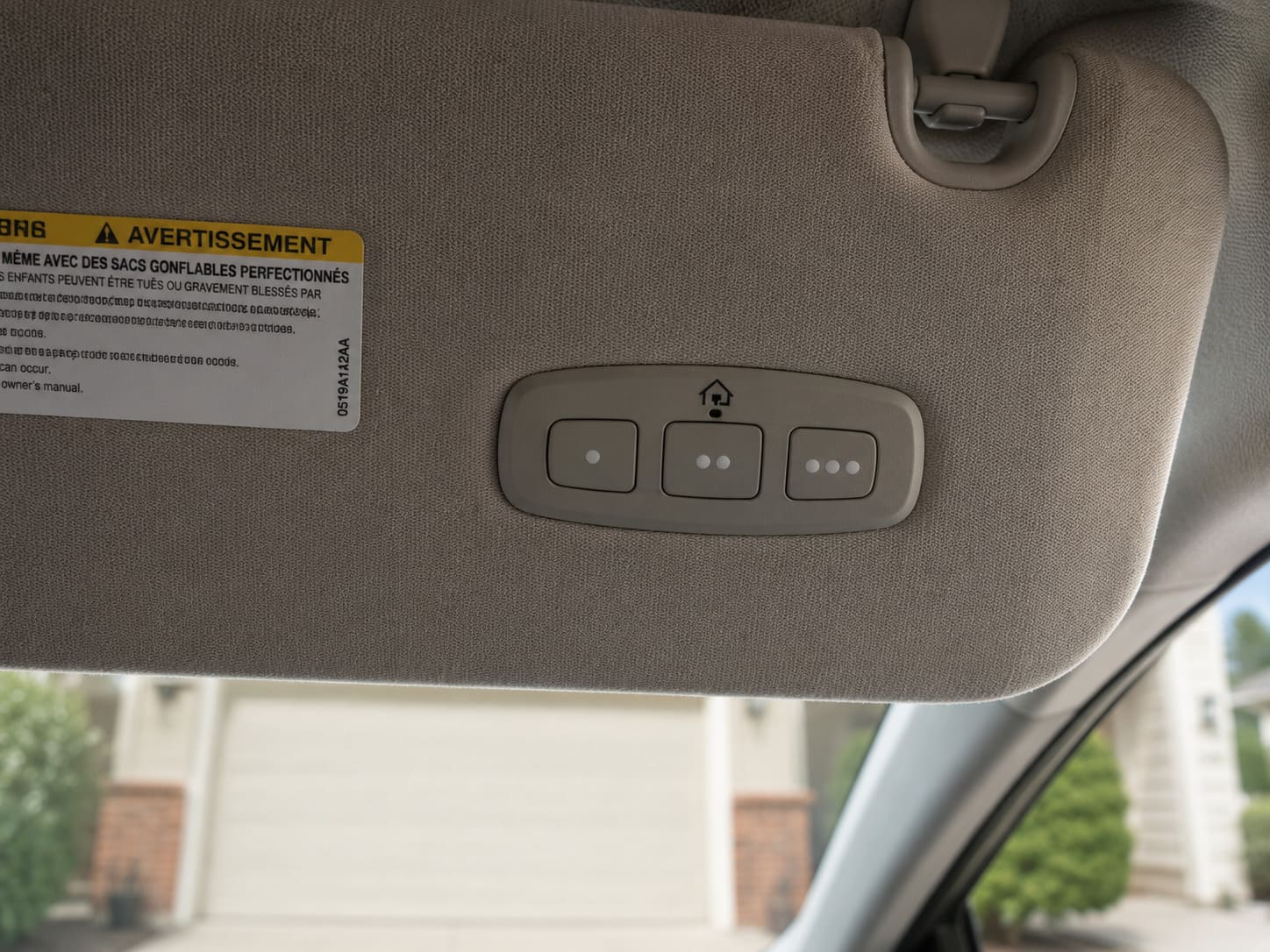 Built-in HomeLink garage door buttons on a car sun visor