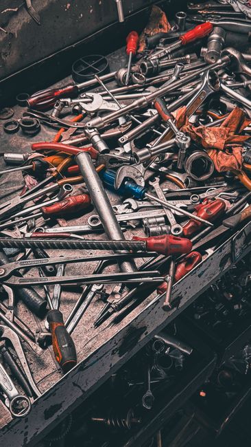 Best Nylon Garage Door Rollers (2026 Picks) 7 Cluttered workbench with hand tools in a garage setting for roller installation