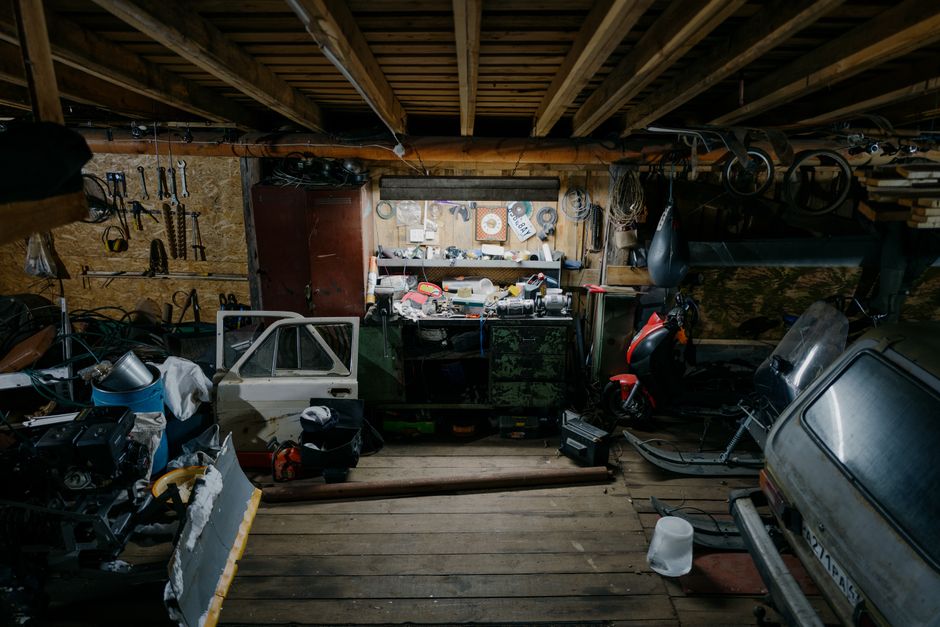 Best Garage Door Torsion Springs (2026 Picks by Cycle Life) 6 Cluttered garage workshop with tools and parts, representing heavier garage doors